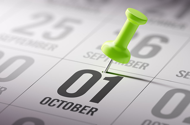 close-up of a stick pin on a calendar, highlighting the date of October 1