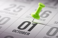 close-up of a stick pin on a calendar, highlighting the date of October 1