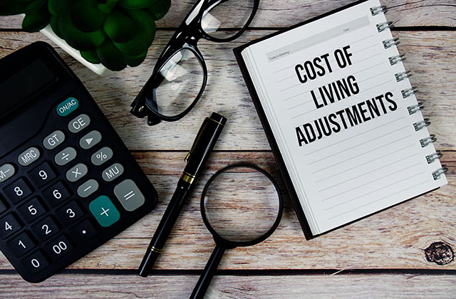 decorative image of a calculator, pens, reading glasses and a notebook