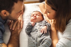 a couple looking adoringly at their newborn child