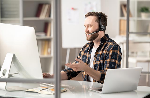 man at desk with telephone ear-piece