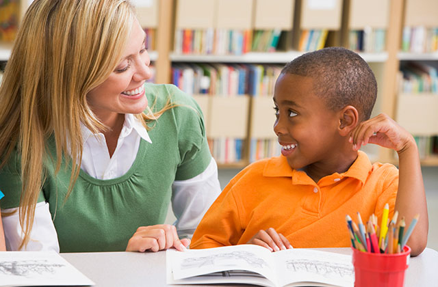 teacher helping student with an assignment at a table