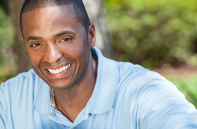young man smiling for camera in an outdoor setting