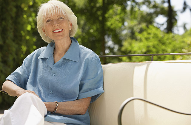 older woman sitting outside smiling