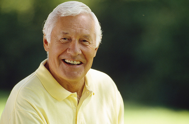 older gentleman smiling for the camera in an outdoor setting