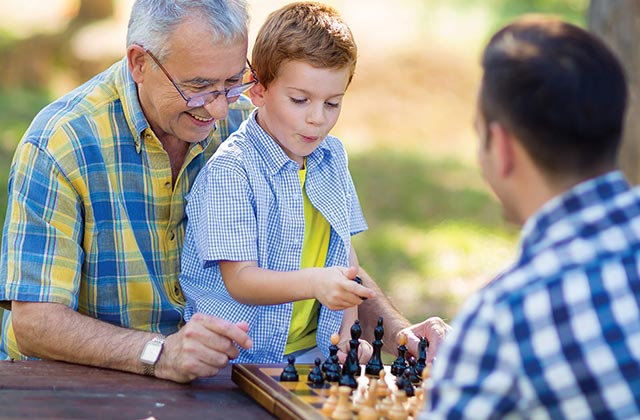 grandfather, father, and son playing chess