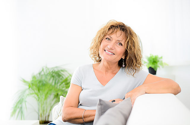 Recent Divorcee lounging comfortably on a couch, smiling